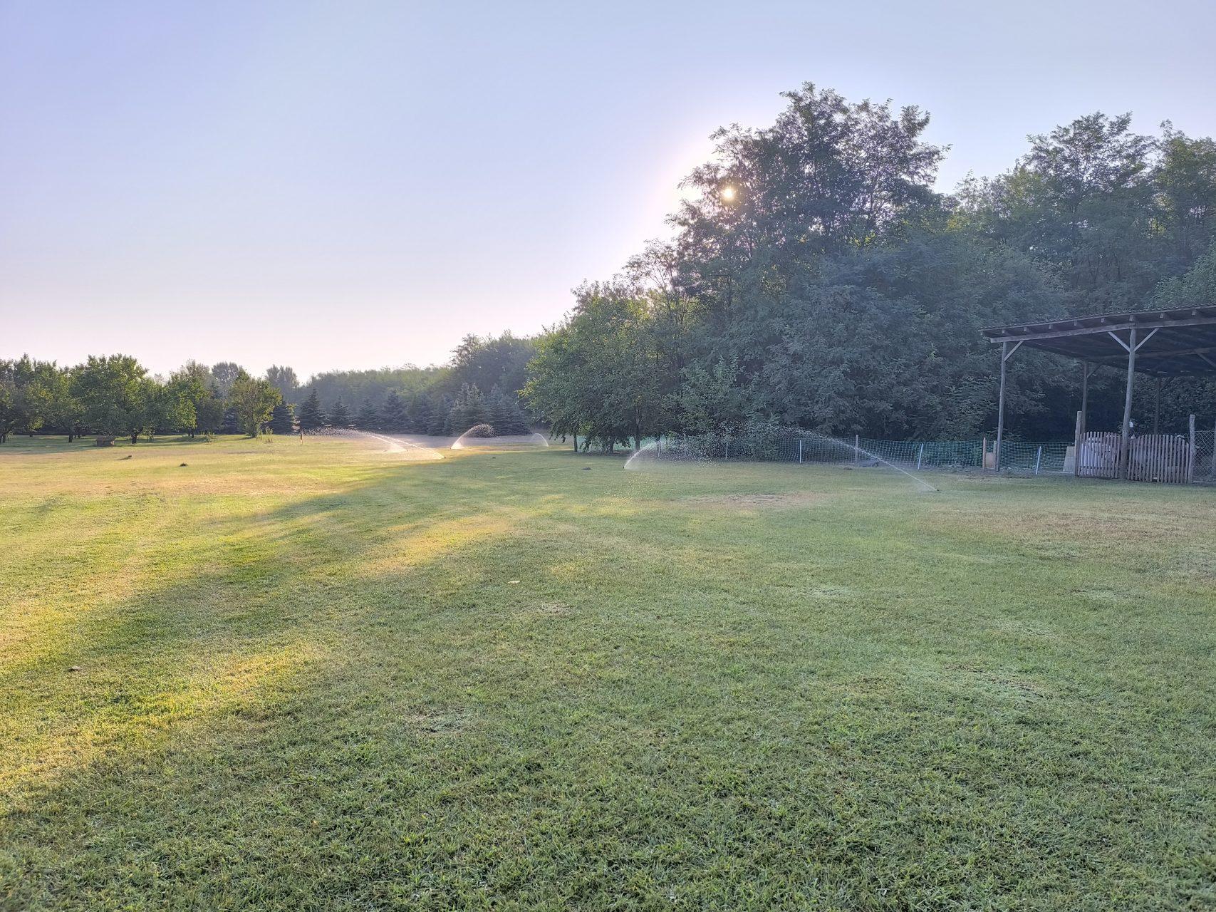 Early morning on the property with sprinklers refreshing the lawn
